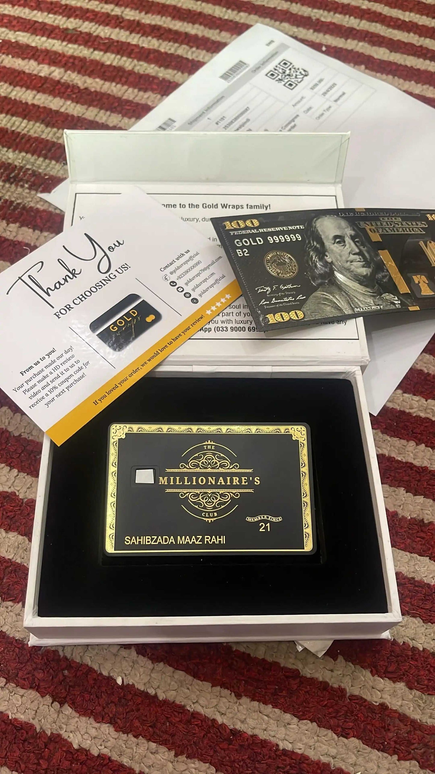 Luxury black and gold metal card in gift box with thank you note and gold-themed card.