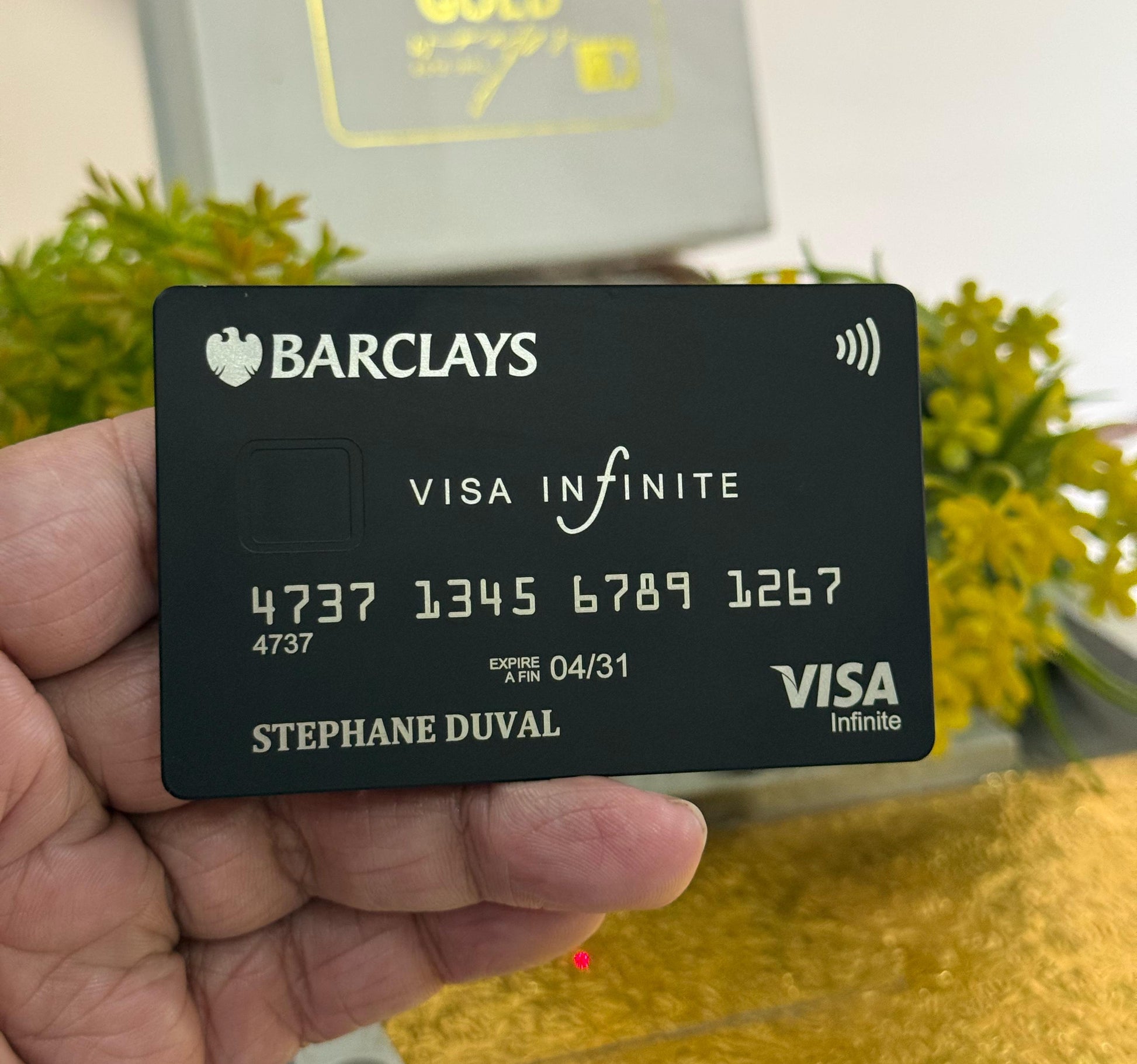 Barclays Visa Infinite card held in a hand with a blurred background