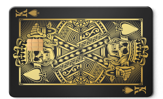 Gold King of Spades metal card with skull design and chip on matte black background