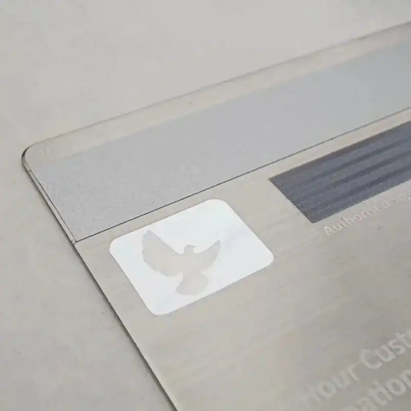 Custom metal card with dove icon, brushed finish, and signature panel