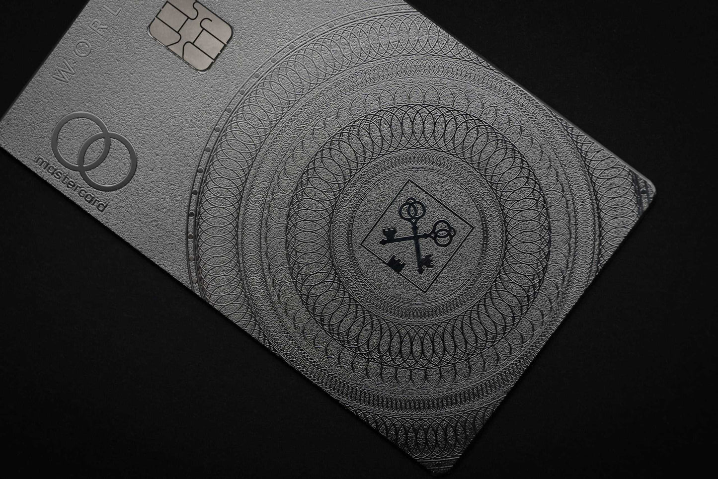 Luxury metal Mastercard with intricate engraved pattern on a dark background