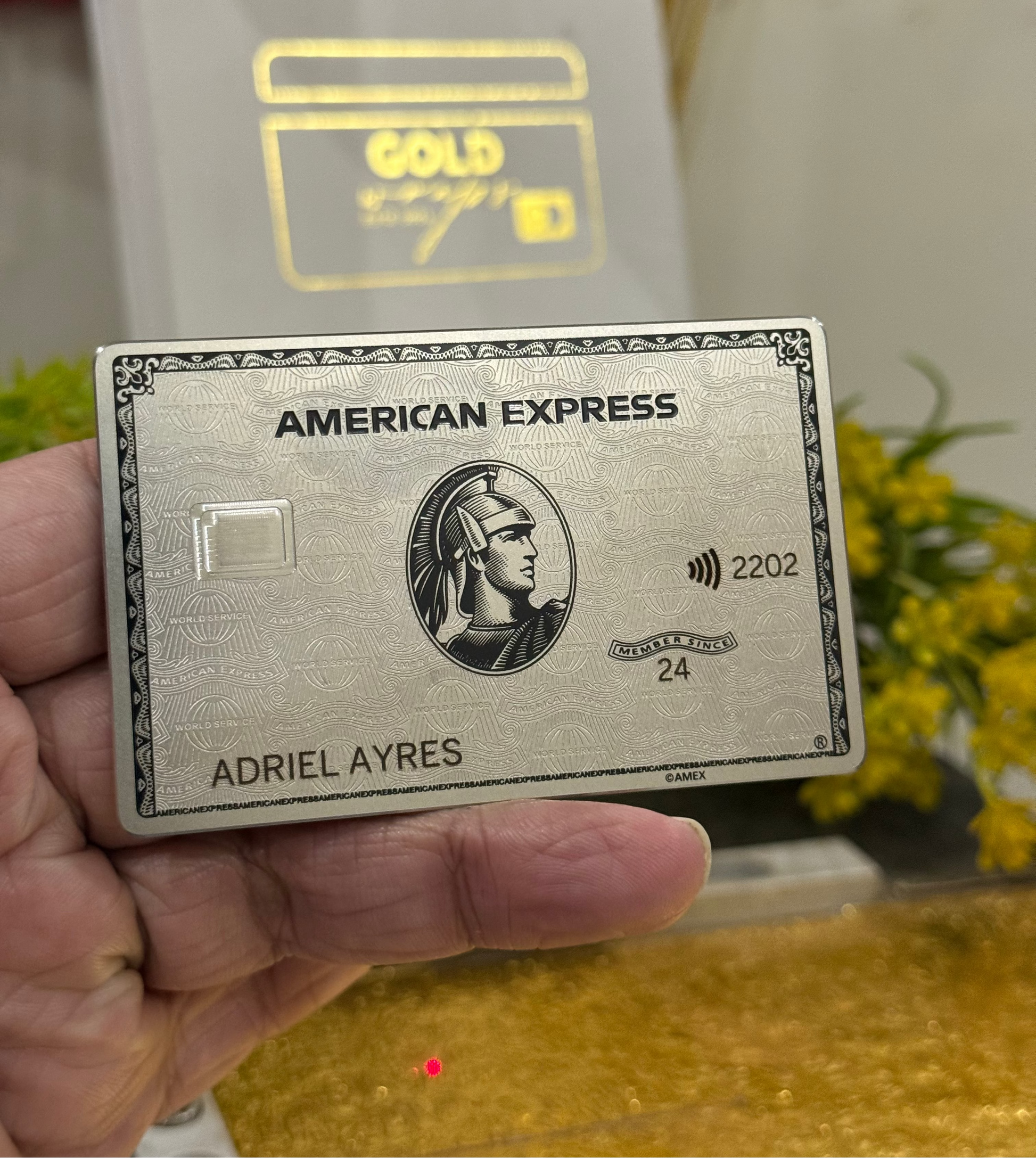 Platinum American Express card held by a hand with a blurred background
