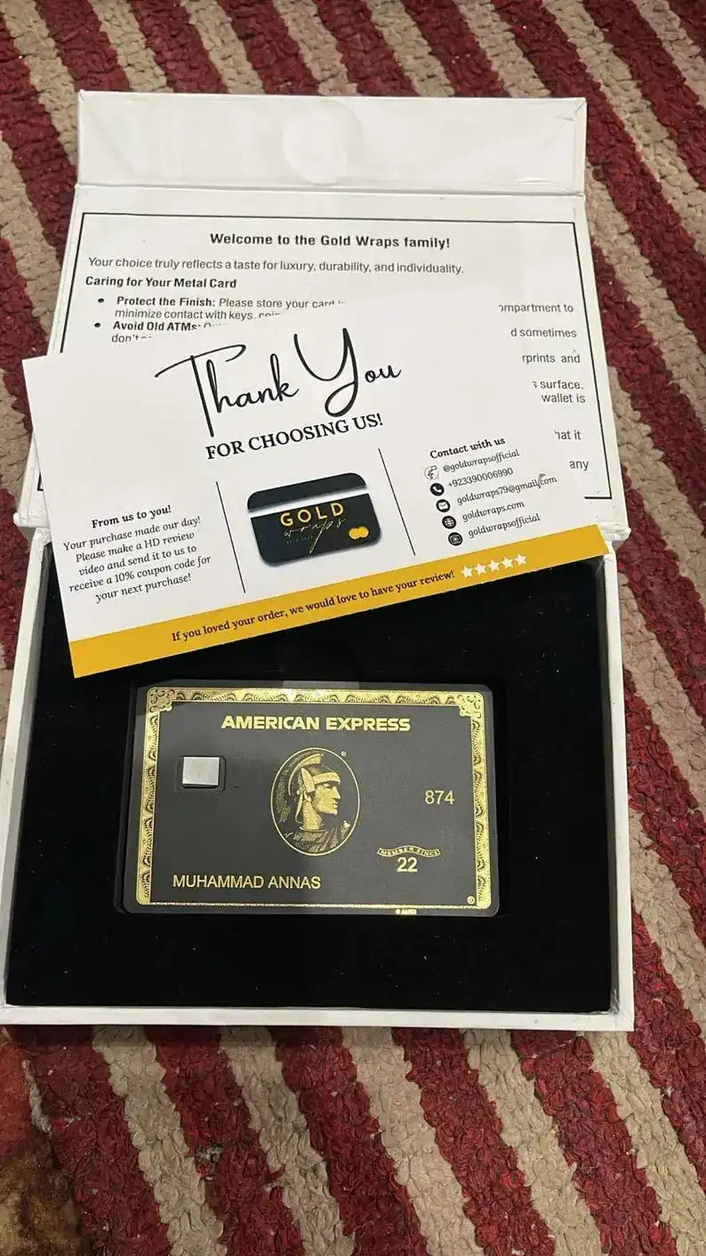 Custom black metal American Express card with gold detailing in gift box on striped carpet