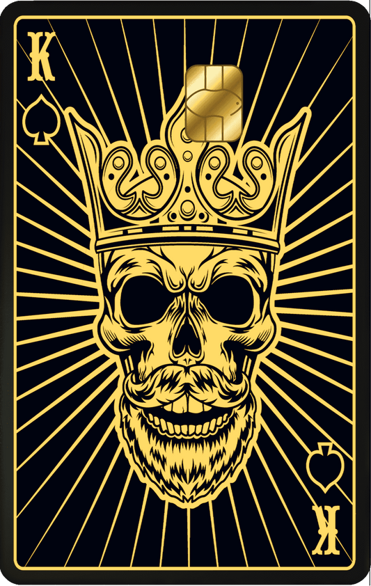Gold metal card featuring a crowned king skull, spade symbols, and radiant lines design.